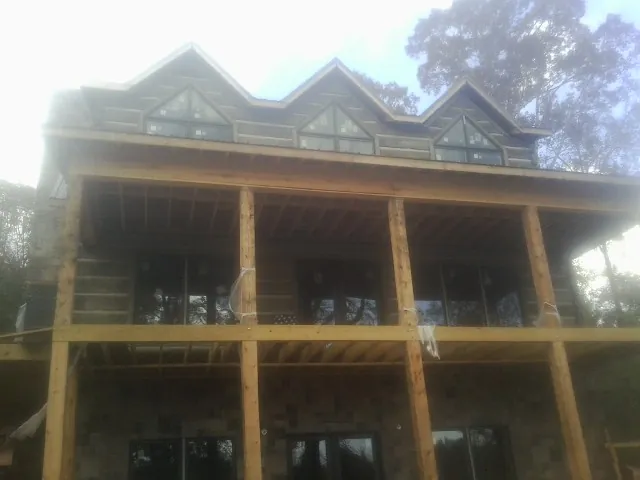 Dormers and porch framing on a large log home under construction — Roof Coating work by our crew in Caldwell