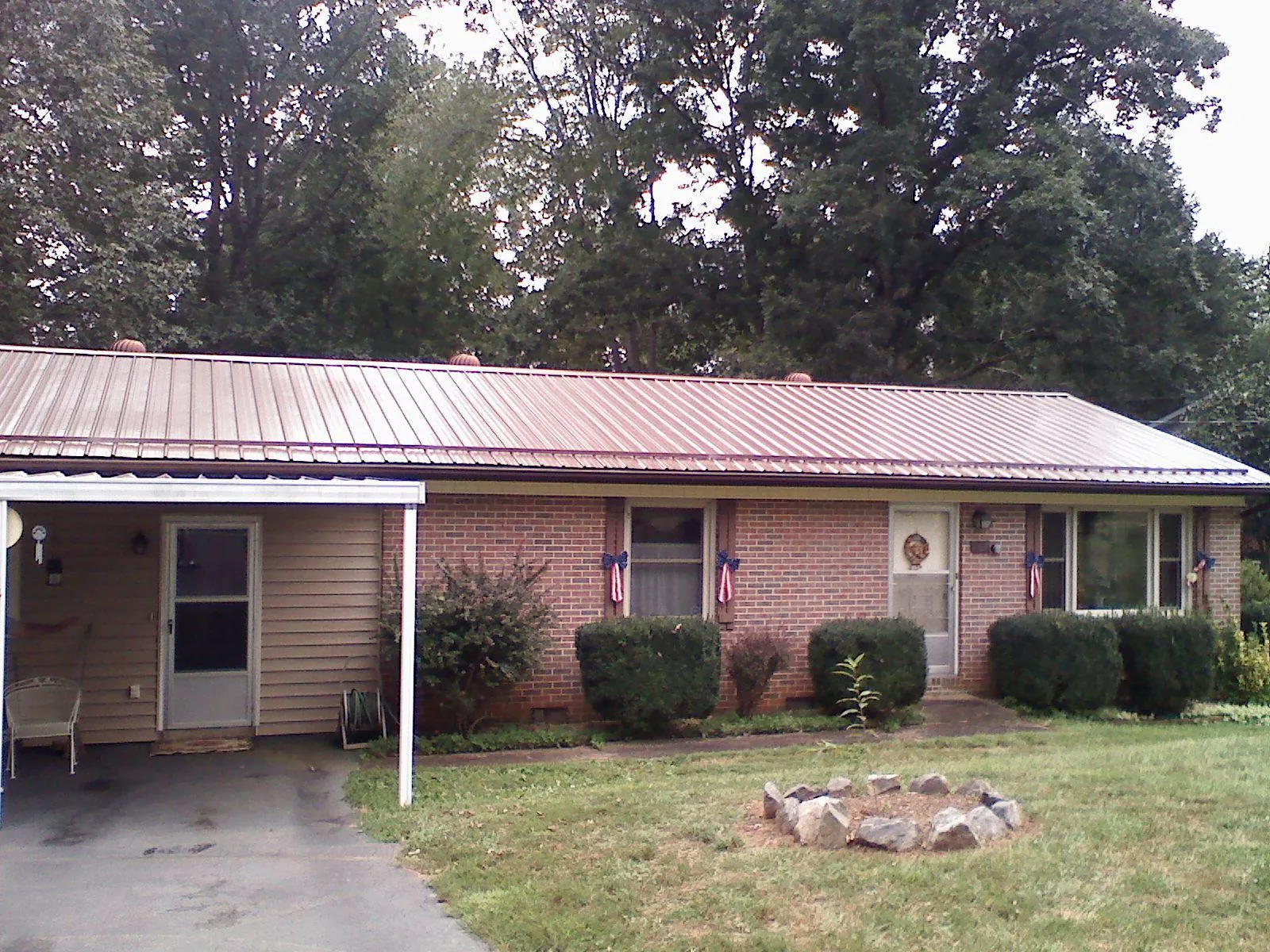Bronze metal roof and carport on a brick ranch home — Roof Repair work by our crew in Caldwell
